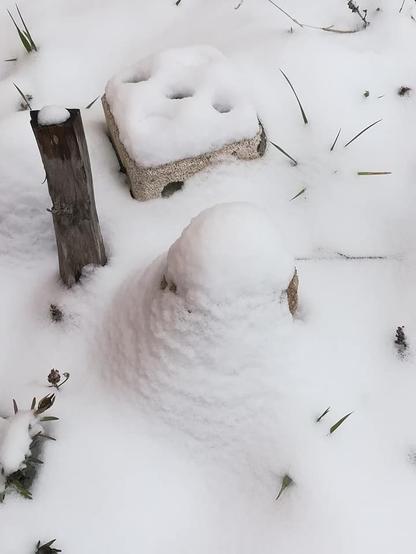 Drei Kunstwerke von Josef Überall mehr oder weniger ganz von Schnee bedeckt. Eine Holzplastik, ein Würfel aus Ytong und eine Buddhafigur, die komplett von Schnee bedeckt ist.