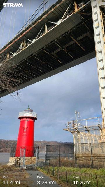 A bright red lighthouse under the George Washington Bridge