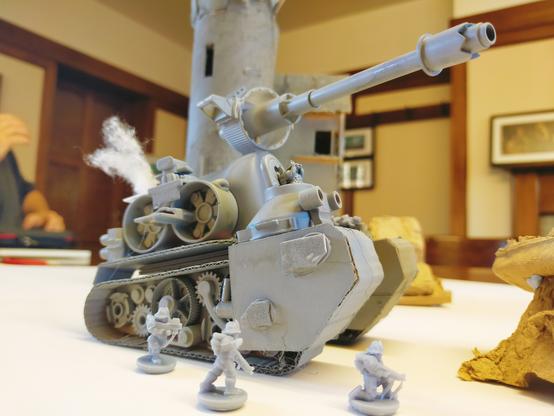 A scratchbuild "Tonk", oversize for the real rules, but I was rushing the build so had to settle. Still it worked. Here it's pictured with 15mm figures for scale.
It appears as a large bulky grey painted tank with futuristic soldiers running alongside.