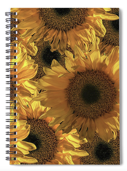 The front of a spiral notebook is covered in bright colorful sunflowers.