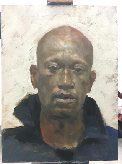 Portrait of a man facing the viewer with a white background.