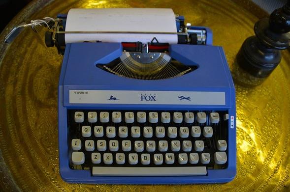 Blue Fox manual typewriter with white sheet of paper