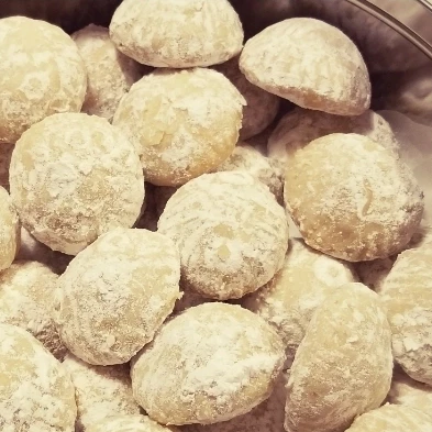 Finished ma'amoul all in a tin covered in powedered sugar and ready to eat.