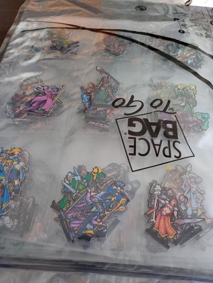 Paper miniatures in a plastic card folder pages, inside a vacuum travel bag.