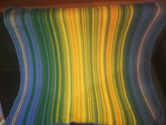 A knitted blanket recording the temperatures throughout 2023. A very temperate year of blues, greens and yellows.