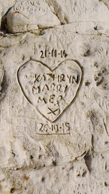 Carved inscription on chalk cliff face. A heart with the words 'Kathryn Marry Me xx'