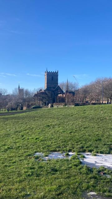 Icy pool in grass, ruined church in background
