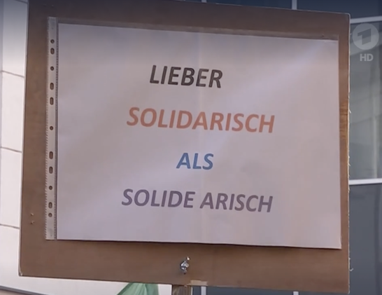 Foto eines Plakats auf einer Demo gegen den Faschismus mit dem Spruch "Lieber solidarisch als solide arisch".