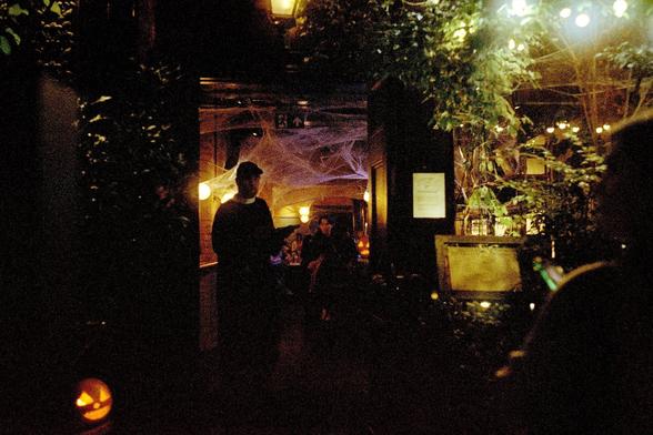 Colour photograph of a host at a bar in Covent garden taking down names for entry.