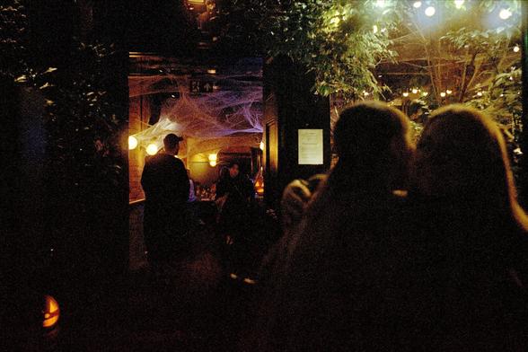Colour photograph of a host at a bar in Covent garden taking down names for entry.