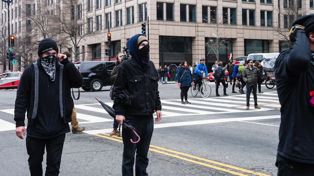 A photograph of two rebels with an umbrella in downtown DC during the inauguration, after the umbrella charge that freed several dozen participants in the march from the police kettle. The J20 case made the umbrella into a symbol of solidarity, showing how seemingly fragile everyday objects can be used to defeat the full force of the police state.