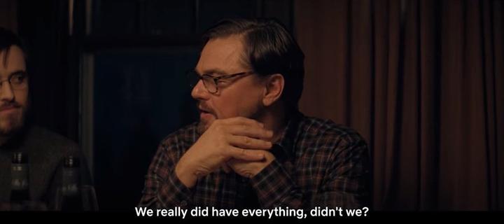 Two men engaged in a conversation at a table with a caption that reads "We really did have everything, didn't we?"