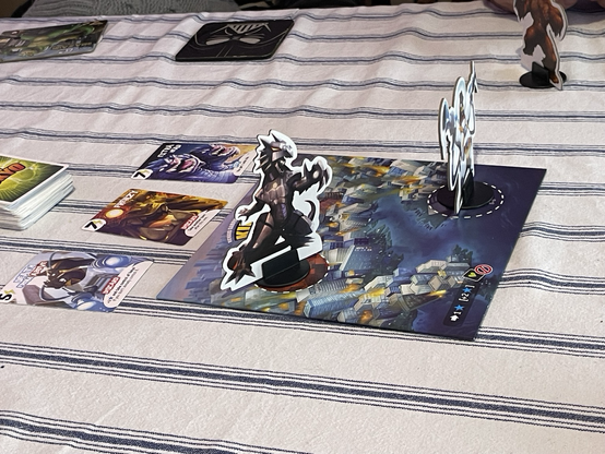 King of Tokyo board with Mecha Dragon in Tokyo City & Space Penguin in Tokyo Bay & 3 power cards above the board