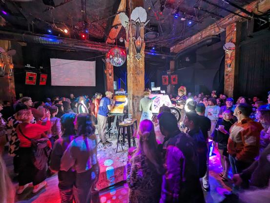 The crowd circles the stage, inspecting paintings I'm progress at Art Battle, a timed art competition in San Francisco.