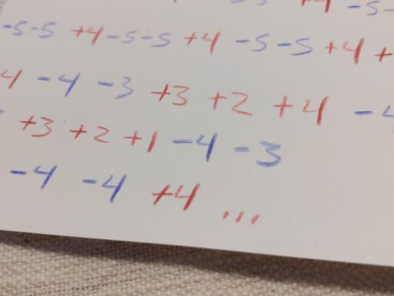 A series of positive and negative numbers written in blue and red colored pencil on a scrap of paper.

It looks like it might mean something...