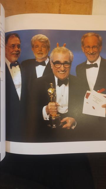Four legendary directors - Martin Scorcese cluthinc his Oscar, with his friends Francis Ford Coppola, George Lucas and Steven Spielberg standing behind him (Lucas is holding up two fingers behind Scorces's head to make bunny ears)
