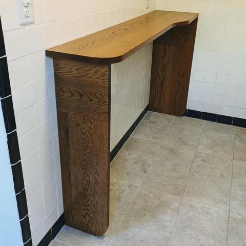A white oak kitchen bar set up against a white tiled wall.