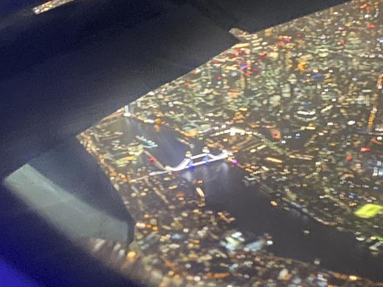 Utsikt over London om kvelden fra flyvindu. Tower Bridge midt i bildet.