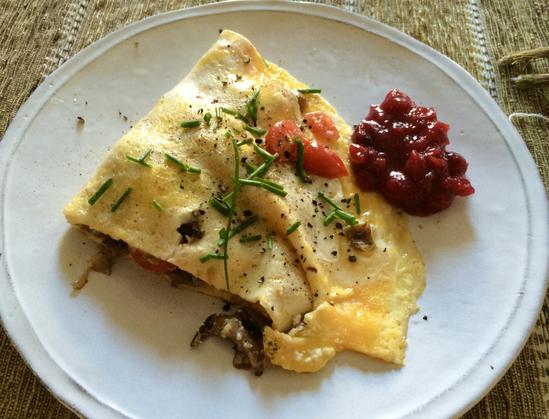 The perfect omelette on a white plate: golden yellow eggs, filled with mushrooms, topped w snipped green chives, and a side of cranberry chutney; the first food I’ve been able to smell and taste, after losing those senses due to Covid.