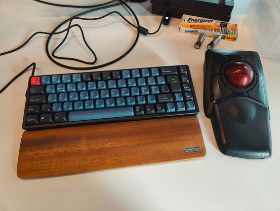 My desk at work with the Keychron K6 Pro, the walnut palm rest and - just because I'm not weird enough already - a Kensington Expert Mouse. Which is a trackball. Weirdly enough.