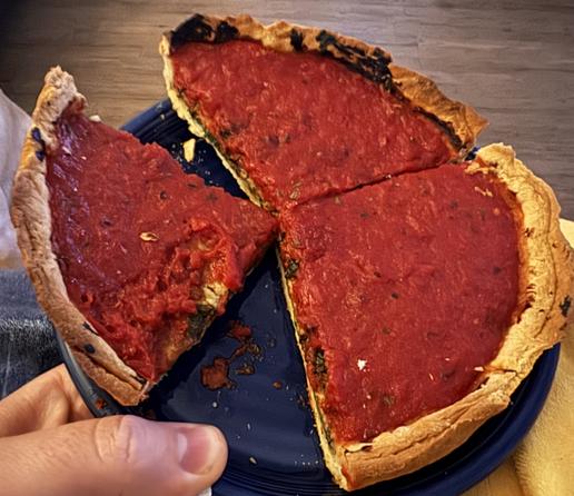 A photo shows three large pieces of pseudo Chicago, deep dish pizza with the typical red sauce on top. Below is cheese and spinach.