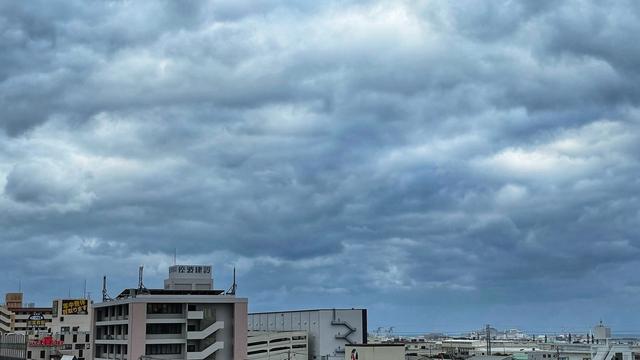 Overcast sky over cityscape with buildings and signage.