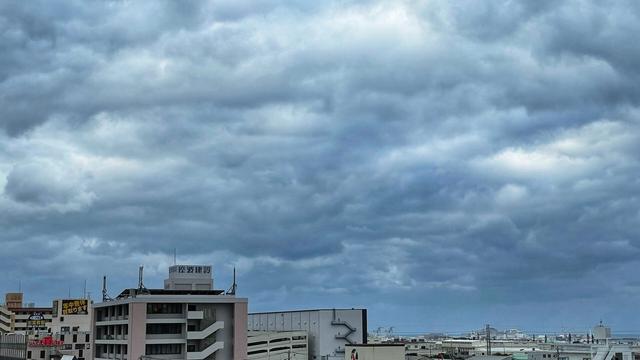 Overcast sky over cityscape with buildings and signage.