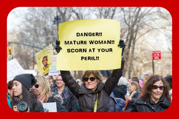 Picture added!

Women demonstrating. A younger woman with camera looking left at front left. A mature woman in shades at front right. A mature woman in shades holding a yellow sign in front centre. Blurred trees and road furniture in the background.
I edited the image to add a red border and change the text of the sign to:
DANGER!!
MATURE WOMAN!!
SCORN AT YOUR
PERIL!!

Original image credit: Mirah Curzer on Unsplash.