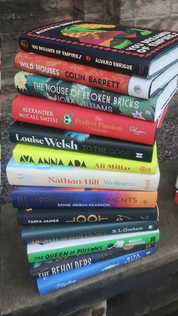 A pile of new hardback novels, spine on to the viewer