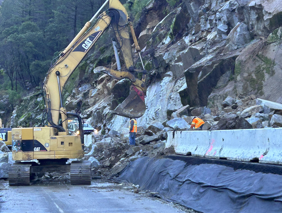 heavy machinery moving rocks off a hillside