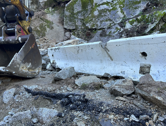 Rocks coming over a freeway barrier