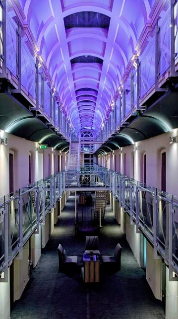 A long tall (three stories) hall with catwalks and metal stairs. Both sides are lined with many cell (room) doors.