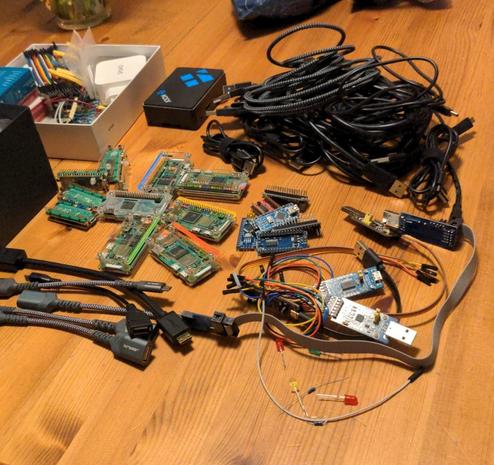 Kursequipment auf einem Tisch: Raspberry Pi Nanos + Picos, Arduinos, Kabel, Adapter …