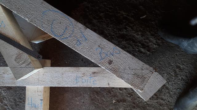 Assemblage du coyau sur l'entrait et l'arbalétrier : on voit plusieurs pièces de la charpente avec des annotations à la craies et les traits au crayons pour les assemblages.