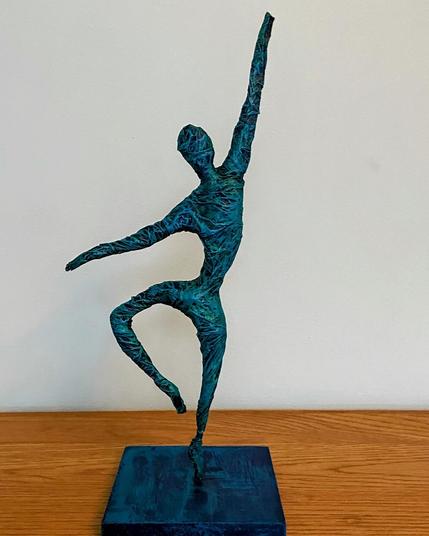 Sculpture of a dancer: on tiptoe, left arm raised high, right arm pointing down
