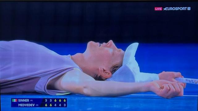 Yannick Donner laying on the floor, eyes closed, savoring his win at the Australian Open