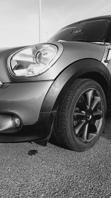Closeup of the front wing of a Mini Cooper S with black alloy wheels