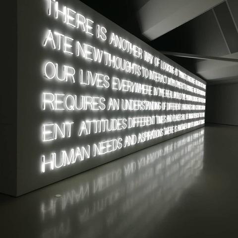 Kunstwerk mit grossen beleuchteten Buchstaben. Zu lesen ist folgender text in versalien: 

THERE IS ANOTHER WAY OF LOOKING AT THINGS LANGUAGE ALLOWS US TO CREATE NEW THOUGHTS TO INTERACT WITH OTHERS TO CHANGE IN EVERY MOMENT OF OUR LIVES EVERYWHERE IN THE REAL WORLD THE HUMAN LONGING FOR FREEDOM REQUIRES AN UNDERSTANDING OF DIFFERENT LANGUAGES AND CULTURES DIFFERENT ATTITUDES DIFFERENT TIMES AND PLACES ALL OF WHICH SPEAK OF THE SAME HUMAN NEEDS AND ASPIRATIONS THERE IS ANOTHER WAY OF LOOKING AT THINGS

Das kunstwerk ist von Maurizio Nannucci ist aus dem jahr 2012 und ist ca. 3,5 meter hoch und 20 meter lang