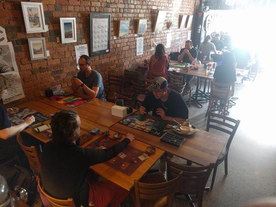 Interior of Baba Hawker board games restaurant in Melbourne. People are mid-game playing Netrunner on every visible table.