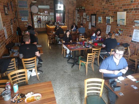 Interior of Baba Hawker board games restaurant in Melbourne. People are mid-game playing Netrunner on every visible table.