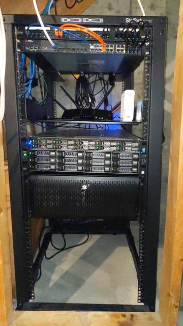 A 25 unit rack with network switch and patch cables at the top, a shelf for wifi router and cable modem, and three rack mount servers.