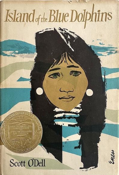 A children's book, The Island of the Blue Dolphins, by Scott O'Dell. The cover illustration is of the face of Native American girl with bands of blue and green flowing behind her, representing ocean waves.