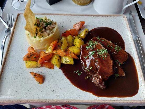 Zart geschmorte Rinderschulter, kräftige Rotweinsauce, glasierte Karotten, nussiges Kartoffelpüree