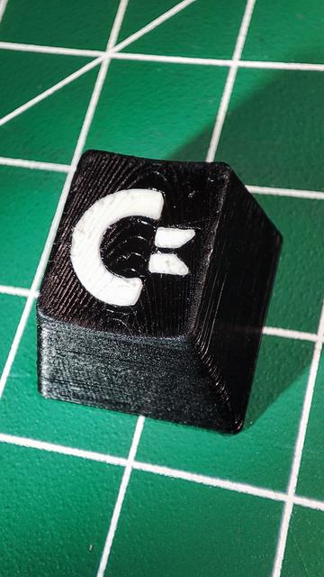 Close up of a black ESC key with a white Commodore logo.