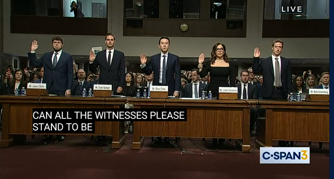 CEOs being sworn in, standing hands raised before congressional testimony.