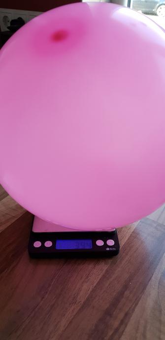 Aufgeblasener, rosa Luftballon auf einer Waage.

Gewicht 3,94 g