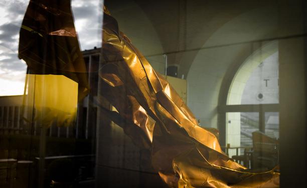 A reflection of a reflection. sky. metal. a copper sculpture twisting outwards.
