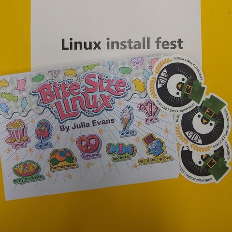 photograph of a Bite Size Linux zine with some Dublin Linux Community stickers