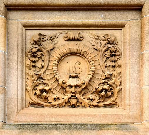 An ornate rectangular cartouche containing a building number.