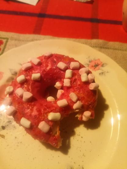 Vaahtokarkkimunkki pumaisella kuorutuksella, vaahtokarkin palaset on hampaan kokoisia. kukkalautanen